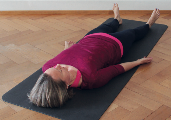 Carla Felber, eine Referentin der Yoga Therapie Ausbildung, liegt in der Yogahaltung Shavasana.