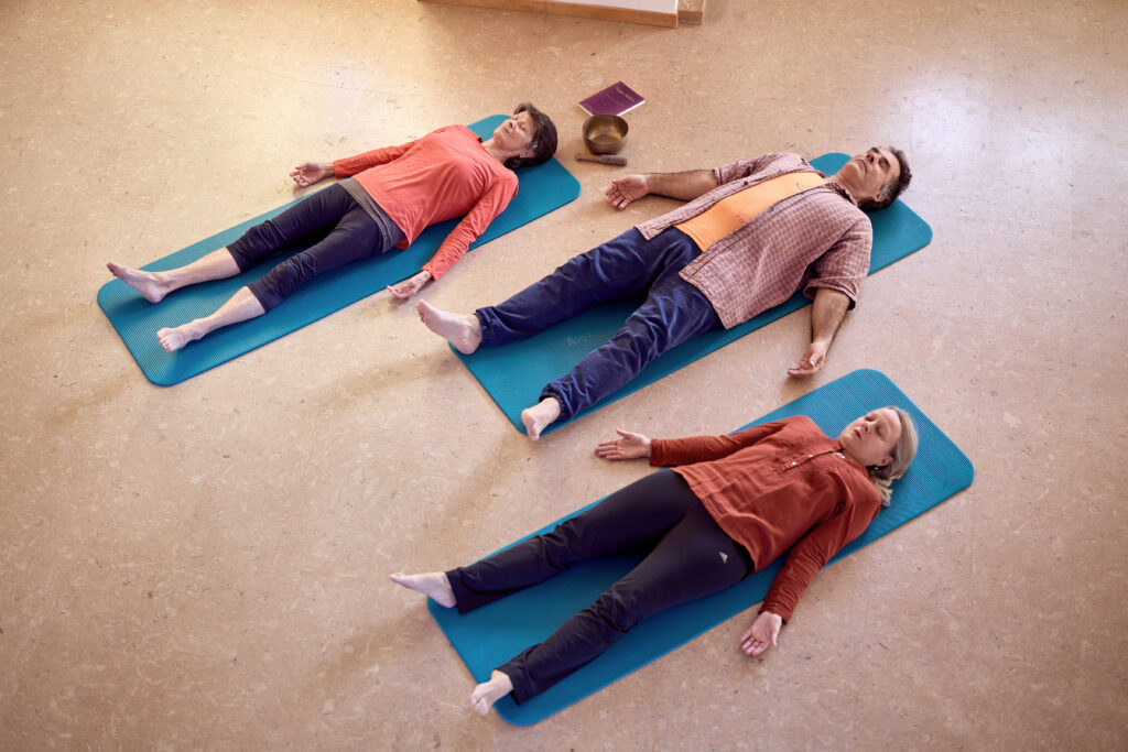 Yoga Nidra Basel – drei Praktizierende liegend in Shavasana