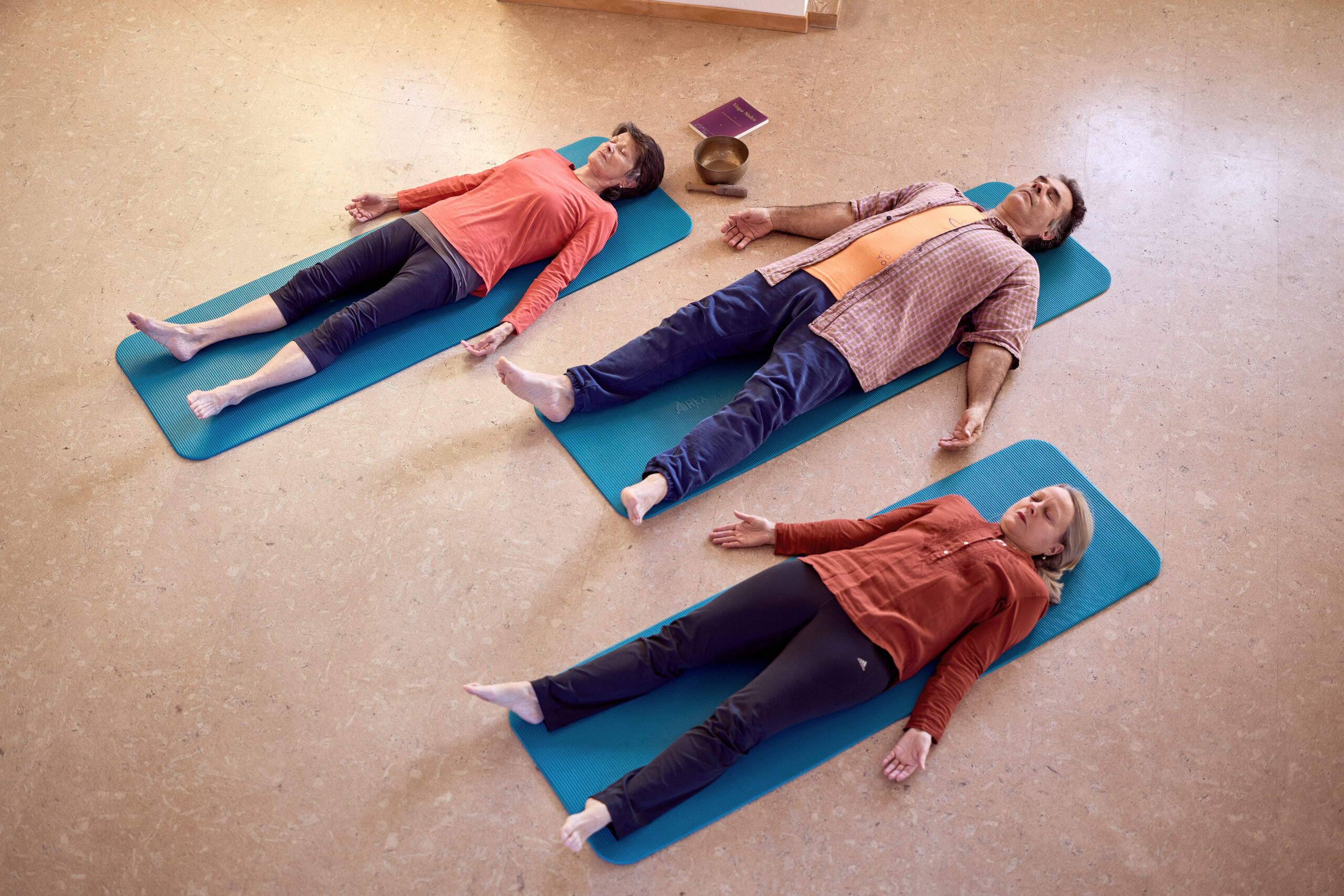 Yoga Nidra Basel – drei Praktizierende liegend in Shavasana