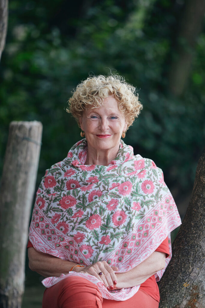 Anna Trökes with curly blonde hair wearing a floral shawl